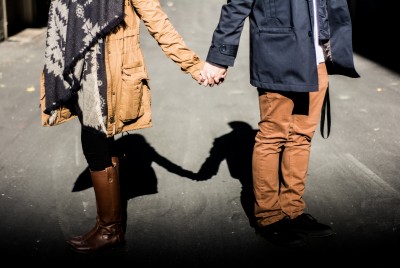 ζευγάρι κρατιέται χέρι-χέρι σε ένα δρόμο