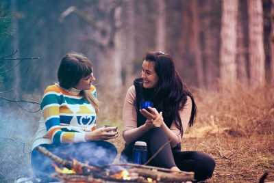 δύο γυναίκες καθισμένες στη φύση μπροστά από μια φωτιά γίνονται φίλες μετά τα 40