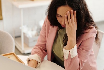 γυναίκα έχει πονοκέφαλο και ψάχνει τρεις τρόπους για να απαλλαγεί από τον ενοχλητικό πόνο