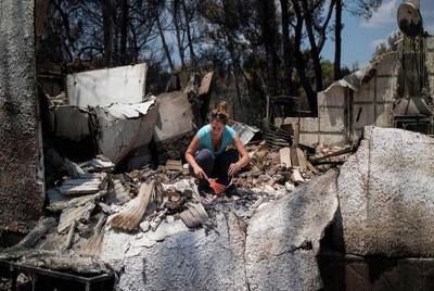γυναίκα σε κατεστραμμένο σπίτι ψάχνει τα συντρίμμια