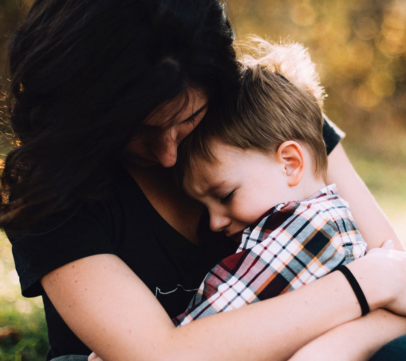 παιδί αγκαλιάζει τη μητέρα του επειδή οι γονείς του χωρίζουν