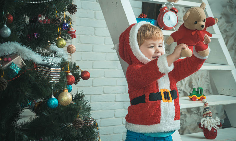 παιδί κρατάει ένα κουτί με χριστουγεννιάτικο δώρο