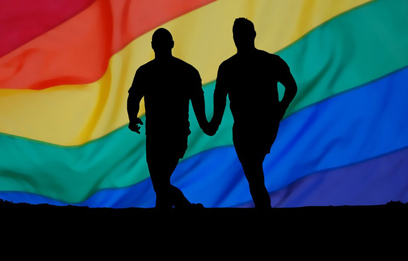 σκιές ομοφυλόφιλων αντρών που κρατούν χέρια σε πολύχρωμο φόντοπολύχρωμο φόντο