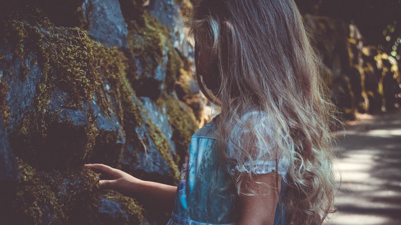 κορίτσι ανακαλύπτει την αξία των περίεργων βρύων σε ένα βράχο