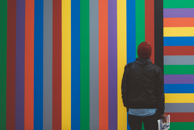 άτομο κοιτάζει διάφορα χρώματα σε ένα τοίχο