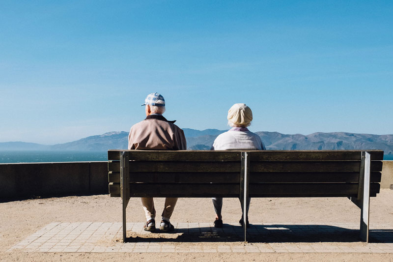 δύο ηλικιωμένοι κάθονται σε ένα παγκάκι