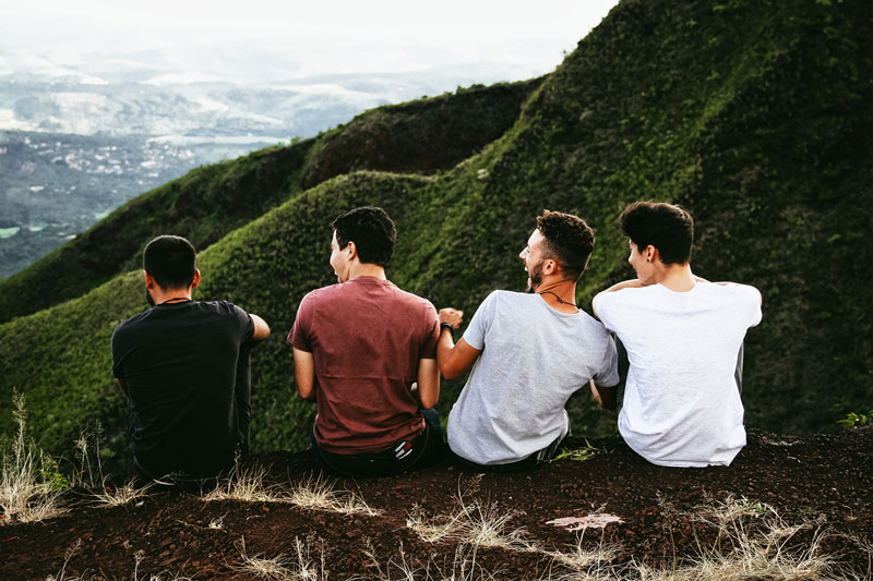 τέσσερις φίλοι κάθονται στη κορυφή ενός βουνού