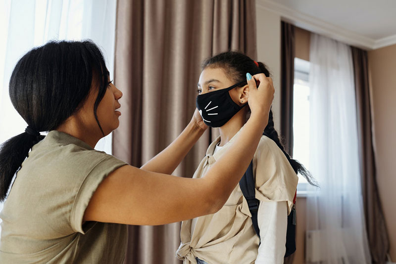μητέρα φοράει μάσκα στο παιδί της και υποστηρίζει την ψυχική υγεία του