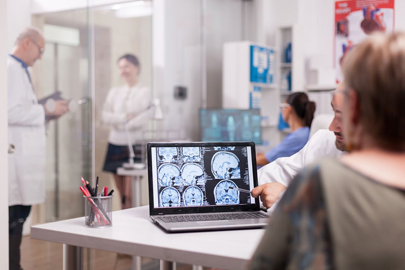 επιστήμονας δείχνει σε ασθενή πόσο ετών είναι ο εγκέφαλός της