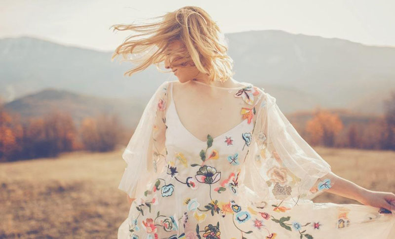 κοπέλα στη φύση με λευκό φόρεμα με λουλούδια