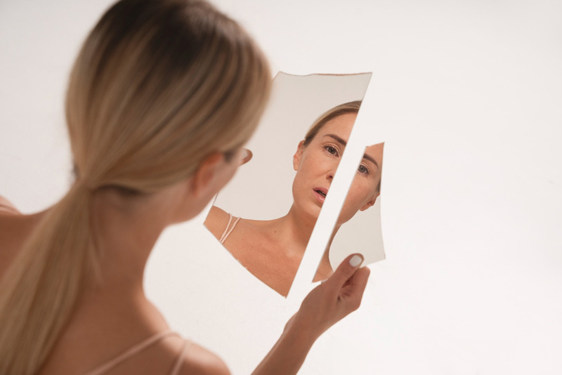 γυναίκα με διατροφικές διαταραχές κοιτάζεται στον καθρέφτη