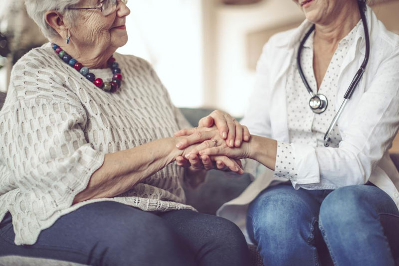 γιατρός κρατάει το χέρι μιας ασθενούς με Αλτσχάιμερ 