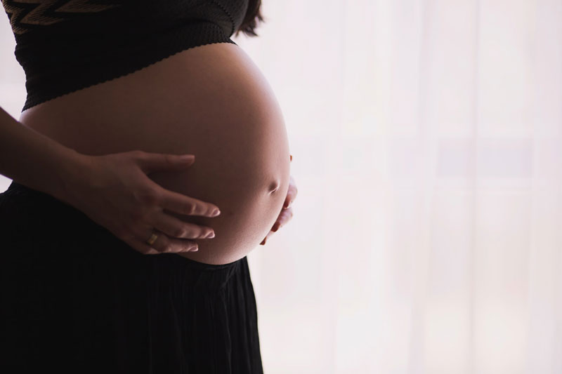 έγκυος γυναίκα παρακολουθεί το μωρό της να μεγαλώνει μέσα της από το κινητό