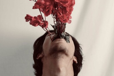 άνδρας με τριαντάφυλλα στο στόμα σκέφτεται την αρρενωπότητα