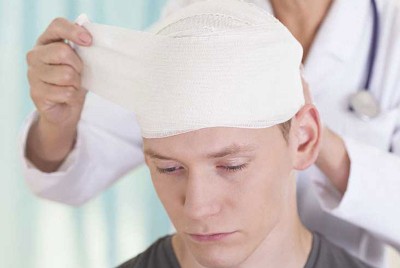 γιατρός βγάζει τους επιδέσμους από έναν άντρα με τραυματισμένο κεφάλι