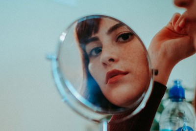 γυναίκα σταματάει να κοιτάζει τον εαυτό της στον καθρέφτη