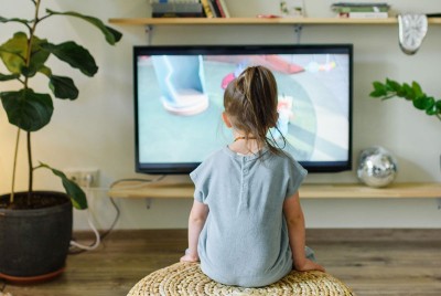 παιδί βλέπει διαφήμιση στην τηλεόραση όπου διαφημίζονται junk food