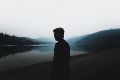 άντρας στην όχθη μιας λίμνης σκέφτεται το κόστος του Φόβου