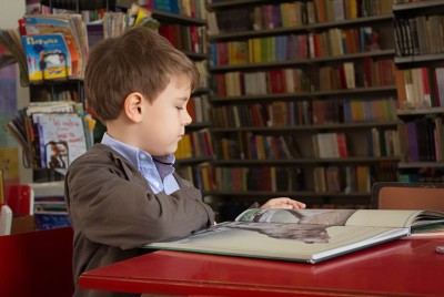 παιδί διαβάζει βιβλίο για τα προγράμματα και τεχνικές παρέμβασης για μαθητές με μαθησιακές δυσκολίες