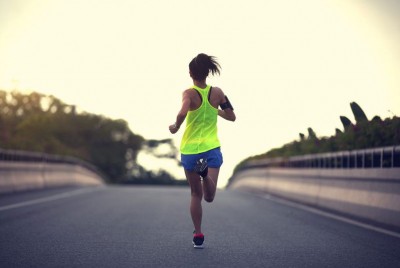 γυναίκα ασκείται τρέχοντας σε ένα δρόμο