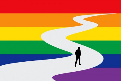 φιγούρα άνδρα που προχωράει μέσα από τα χρώματα LGBT