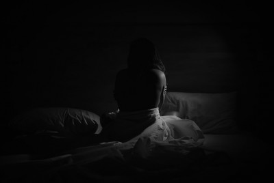 γυναίκα σε κρεβάτι που βίωσε μη συναινετική πορνογραφία