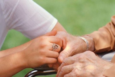 χέρια φροντιστή καθησυχάζουν ασθενή με Αλτσχάιμερ