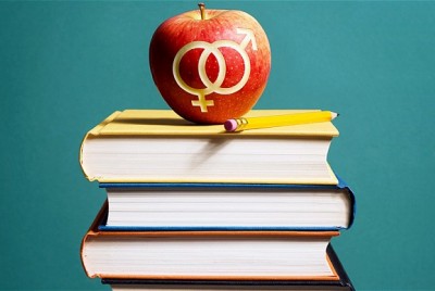μήλο με χαραγμένα τα σύμβολα των φύλων πάνω σε βιβλία