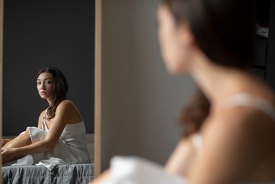 μία κοπέλα με αρνητική εικόνα σώματος κοιτάζεται στον καθρέπτη