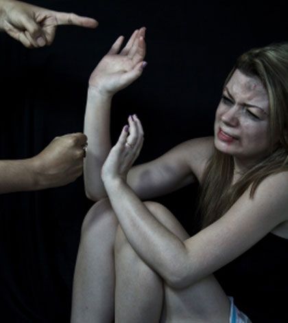 γυναίκα κακοποιημένη που υψώνει το χέρι της και ένα αντρικό χέρι ετοιμάζεται να τη χτυπήσει