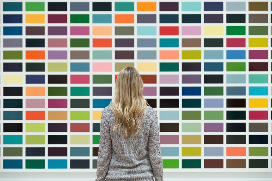 Μία γυναίκα κοιτάζει έναν πίνακα με χρώματα